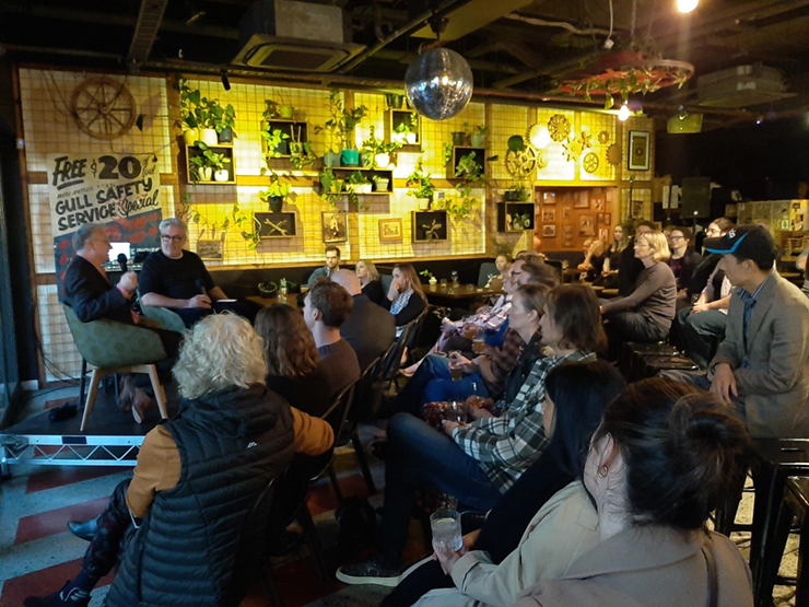 Group of people in a bar sitting listening to a presenter